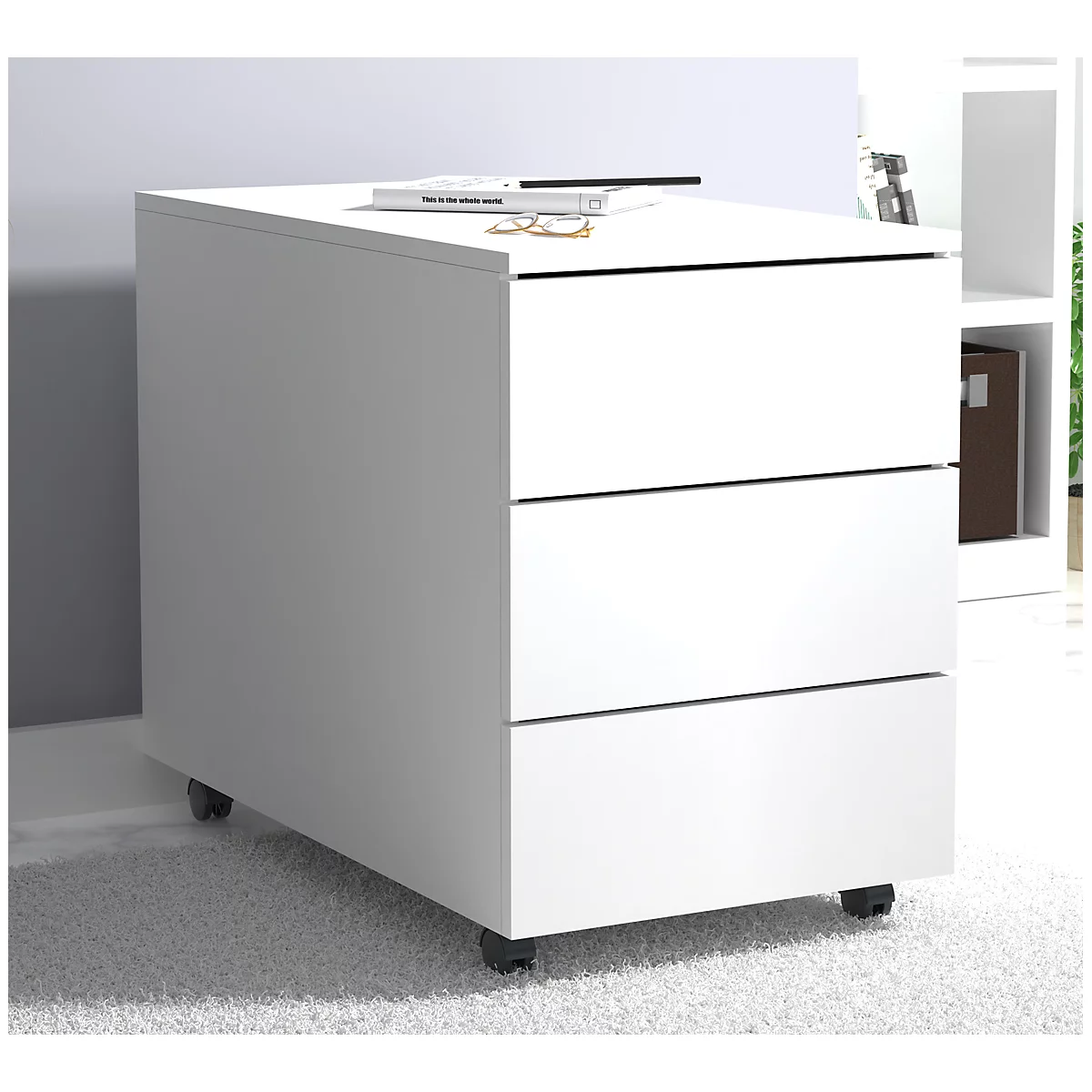 White rolling file cabinet with three drawers. Book, glasses, and pen on top.