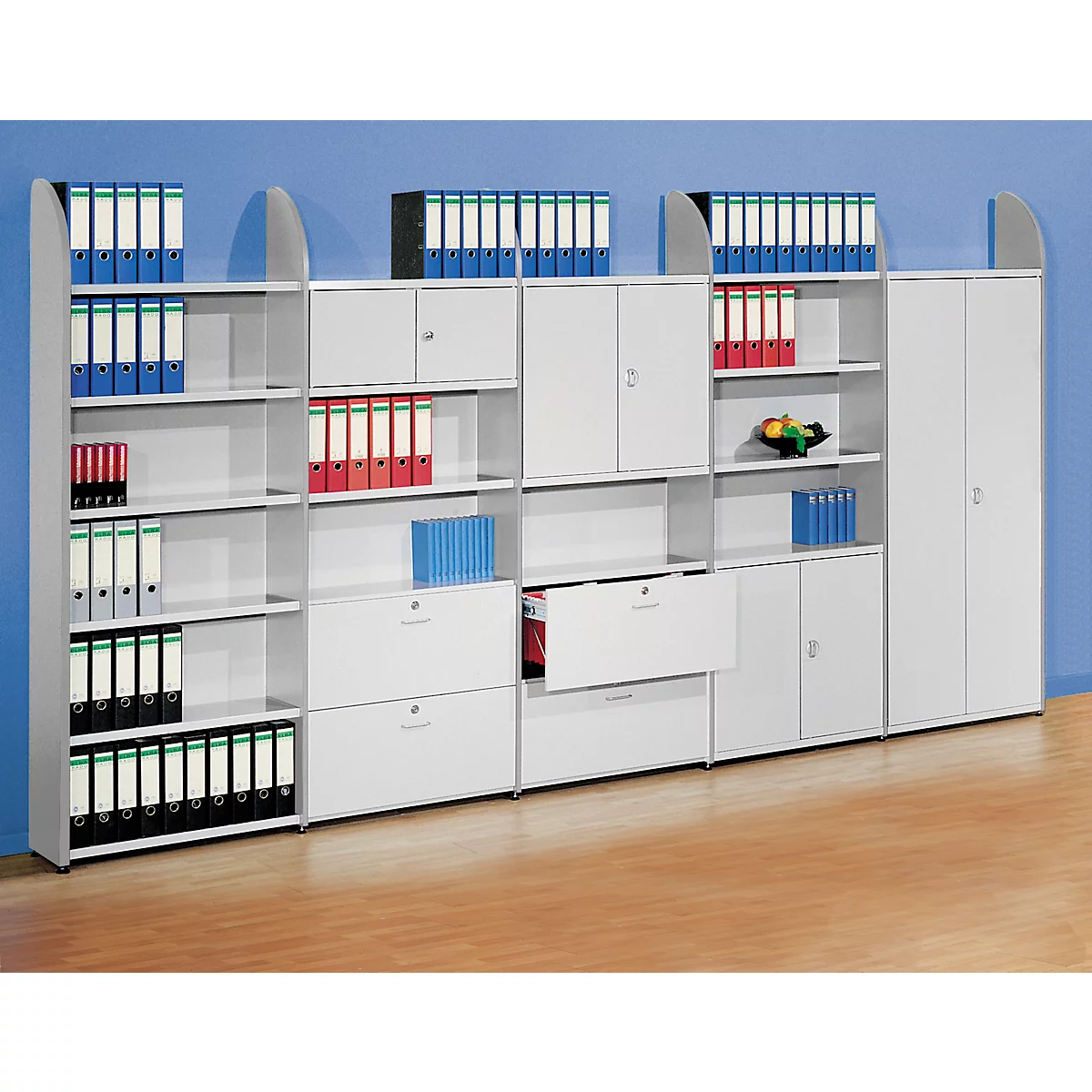 White office shelving unit with binders, drawers, and cabinets. Binders in various colors, set against a blue background.