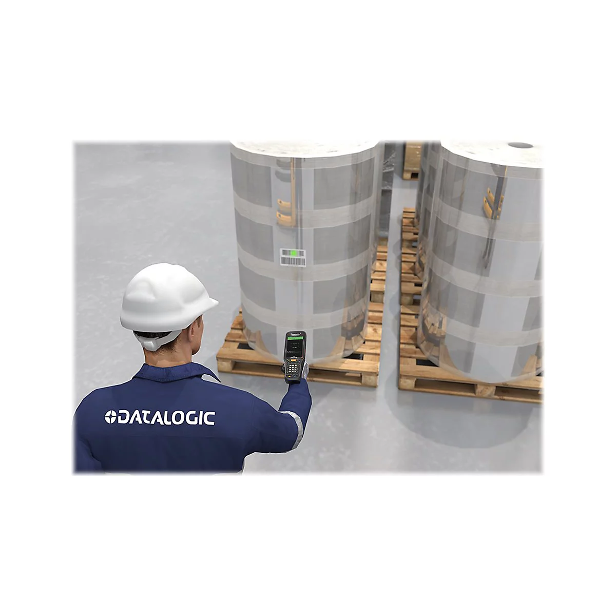Ein Arbeiter scannt Barcodes auf Papierrollen. Er trÃ¤gt eine blaue Arbeitskleidung mit Datalogic-Logo und einen weiÃŸen Helm.