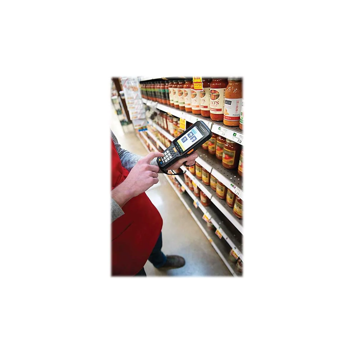 Person scannt Waren im Supermarktregal mit Handscanner. Regale sind mit Konserven gefÃ¼llt.