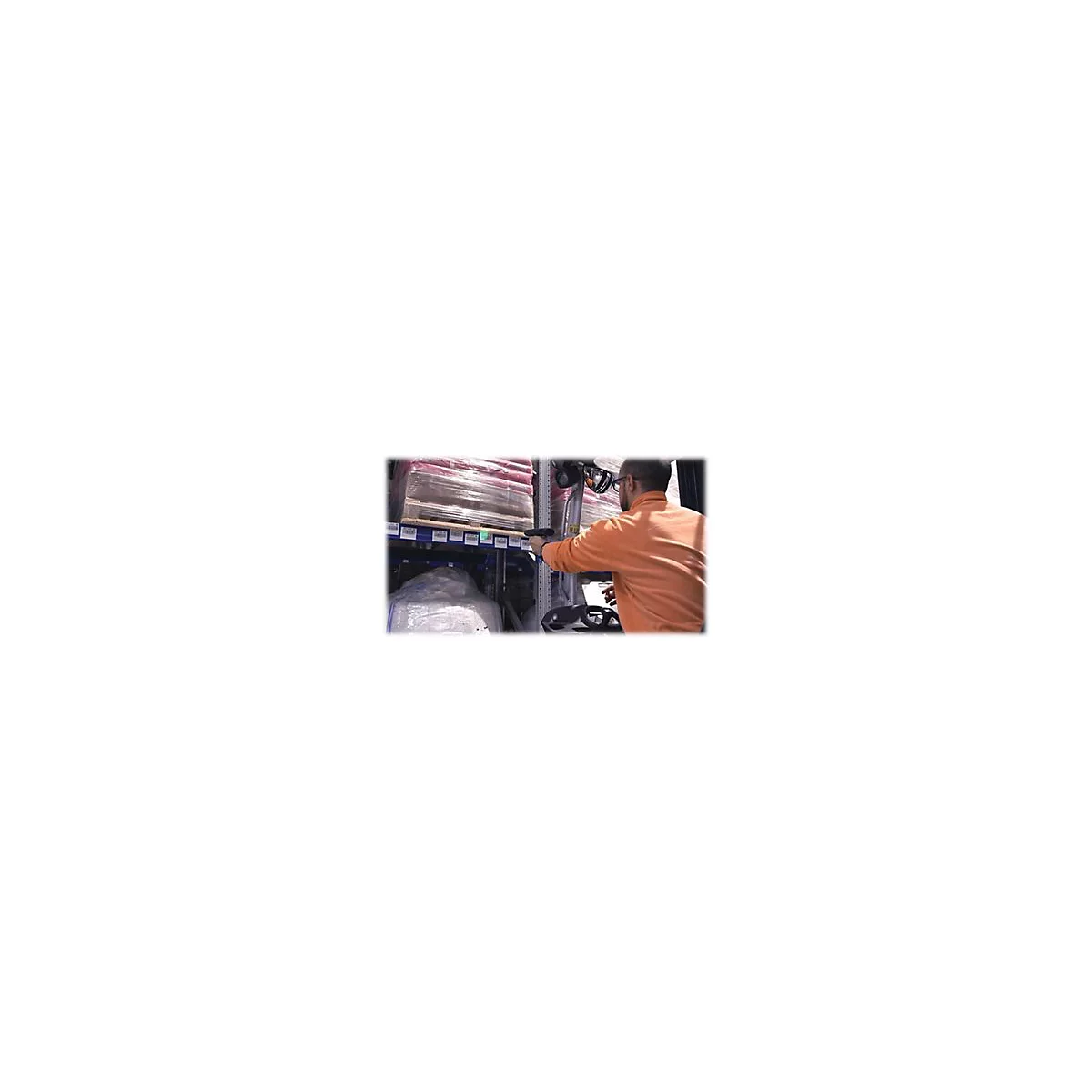 Ein Mann mit Brille und orangenem Shirt scannt mit einem Handscanner Waren in einem Lager. Er sitzt in einem Gabelstapler.
