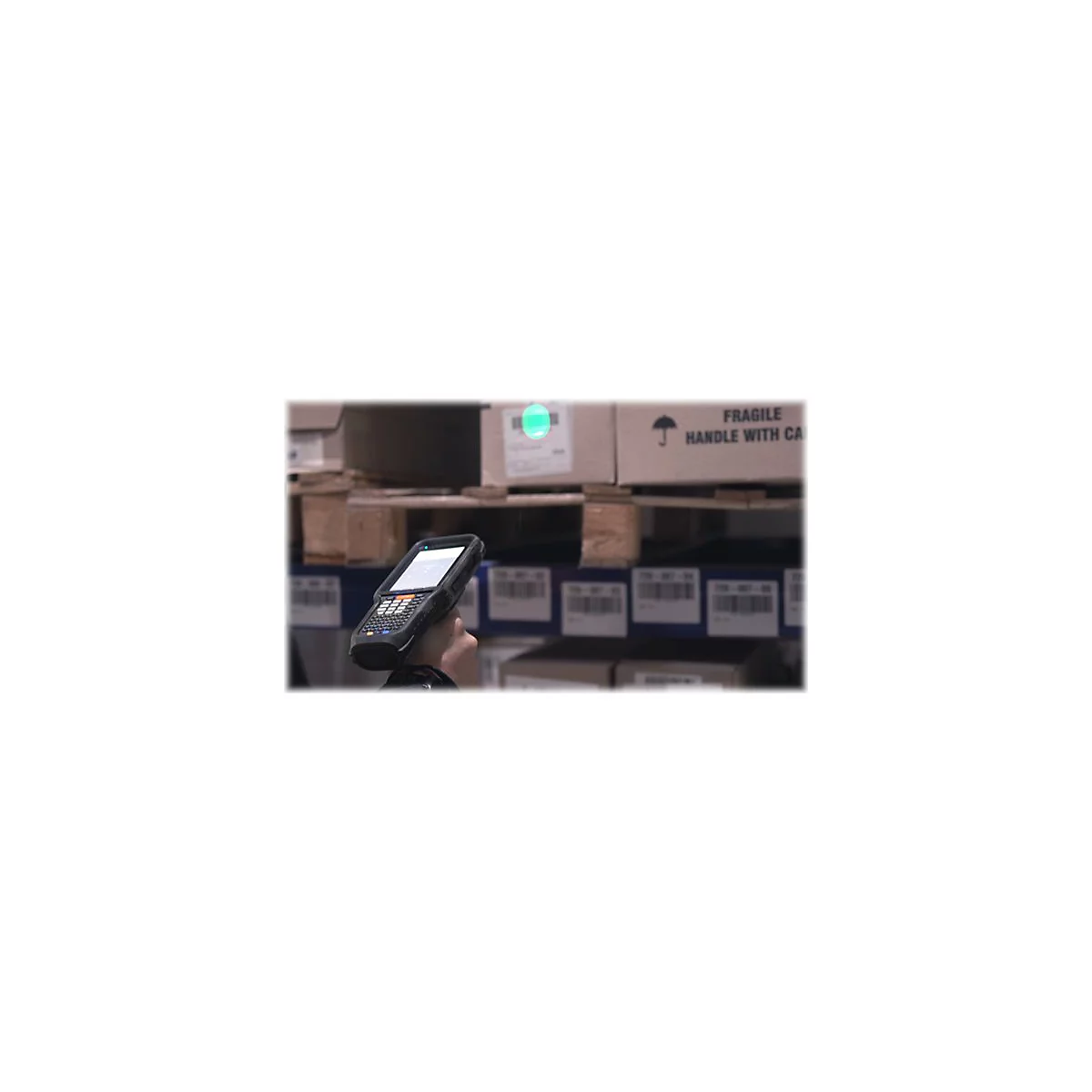 Handheld-Scanner scannt Paket in Lagerregal. Auf dem Paket steht 'FRAGILE, HANDLE WITH CARE'.