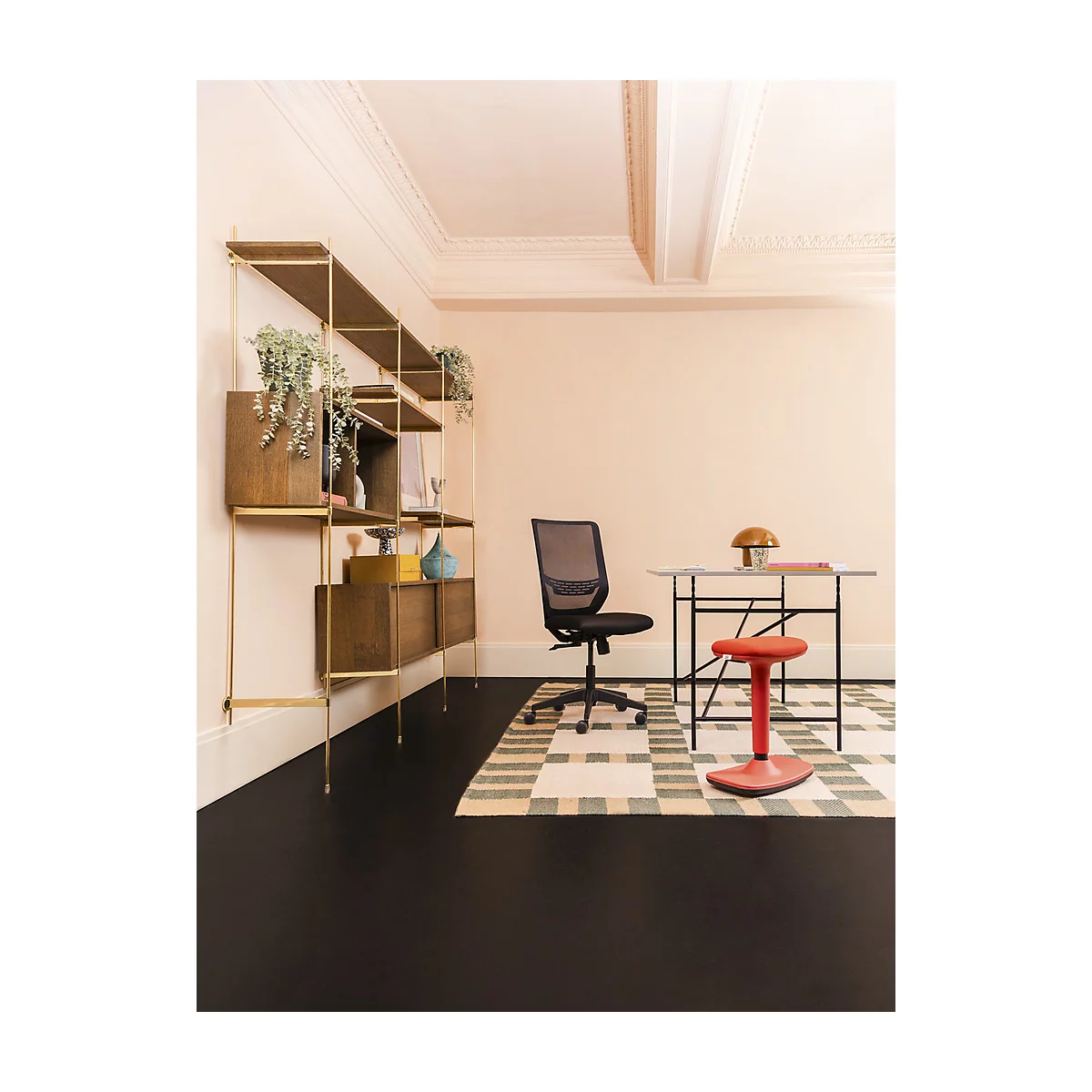 Modernes Heimbüro mit schwarzem Boden, Wandregal aus Messing und Holz, Schreibtischstuhl und einem roten Hocker.