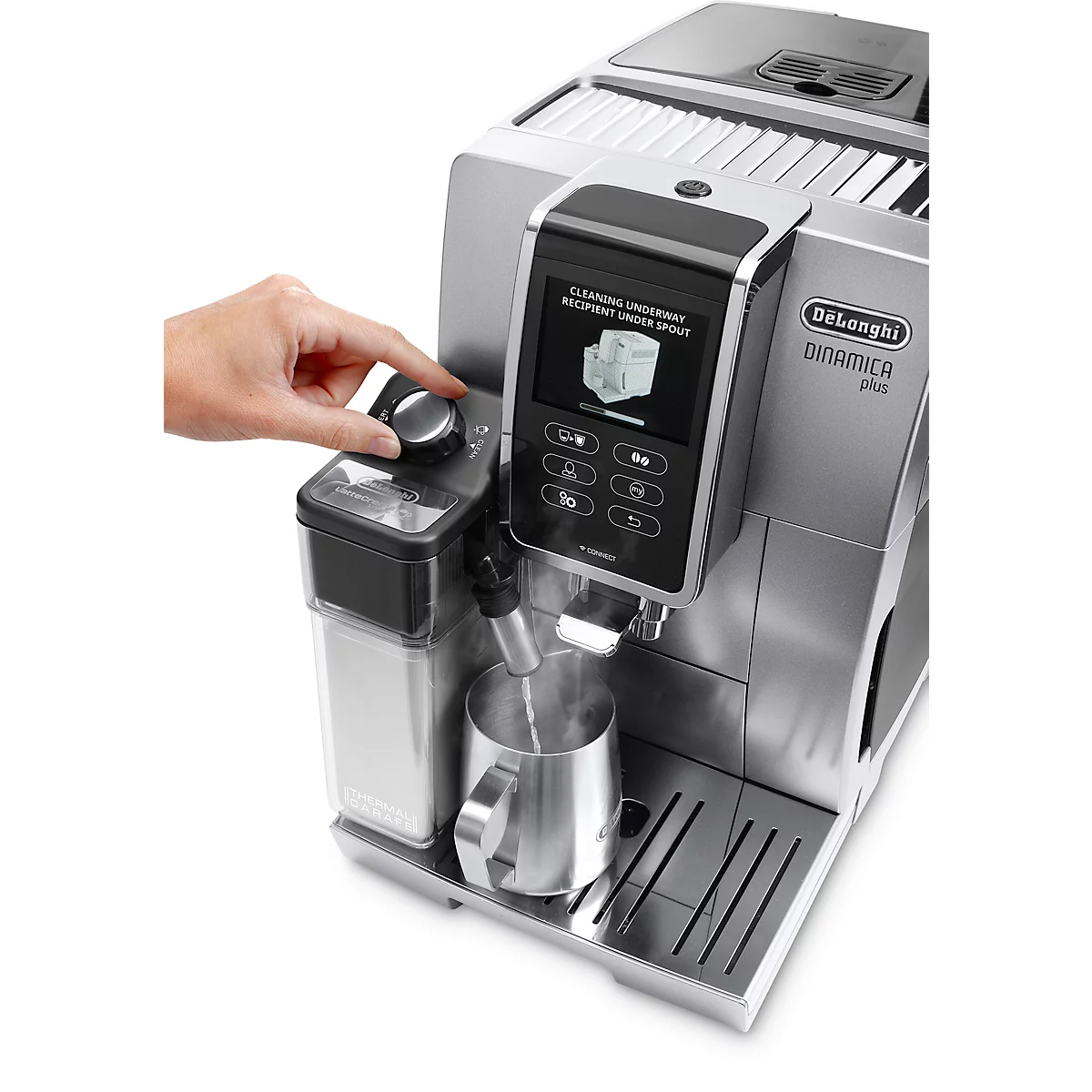 Eine Person bedient eine silberfarbene De'Longhi Dinamica Plus Kaffeemaschine. Auf dem Display wird die Reinigung angezeigt. Dampf kommt aus dem Ausguss.