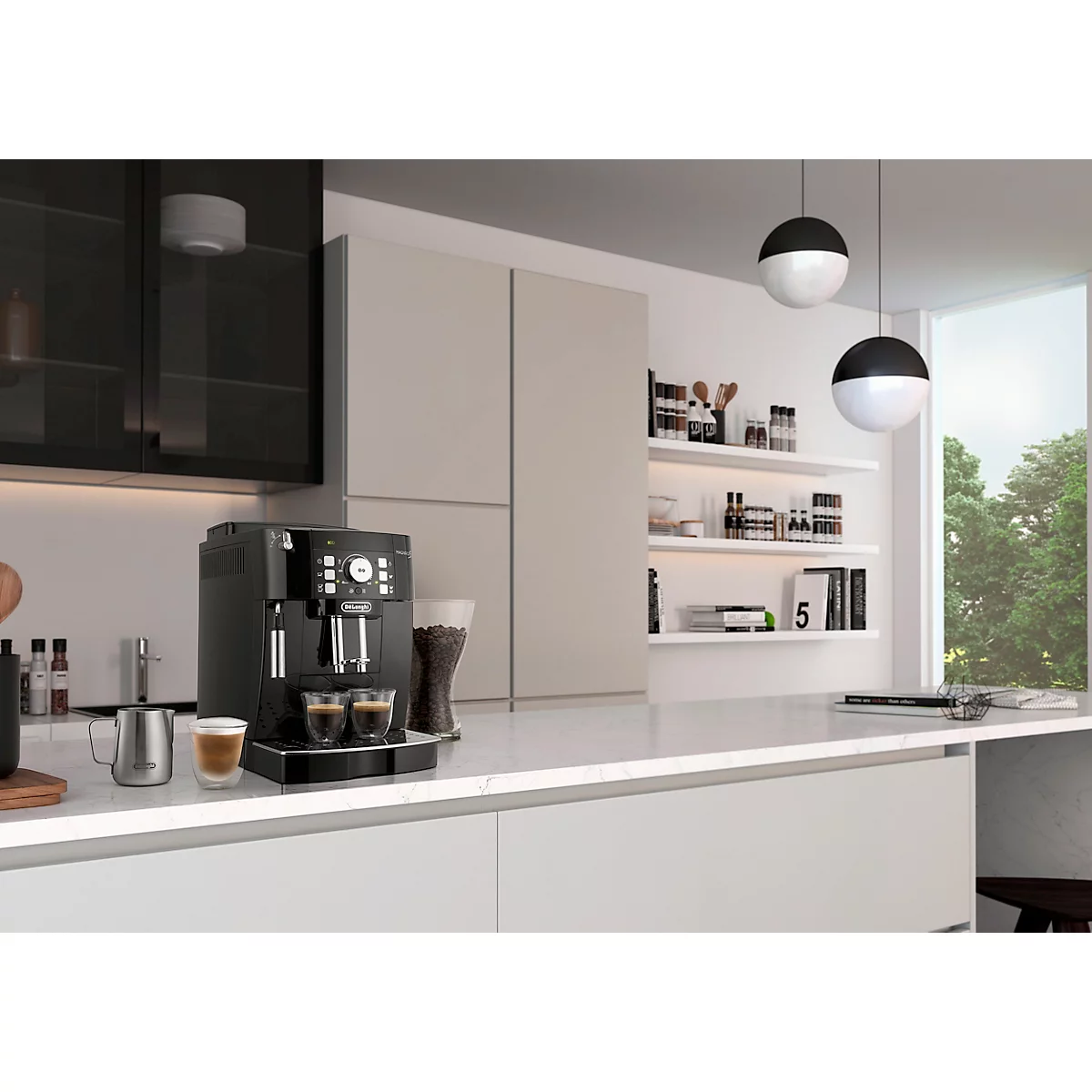 Schwarze Kaffeemaschine auf einer Küchenzeile, daneben Tasse Kaffee, Gläser. Im Hintergrund Küche mit Fenster.