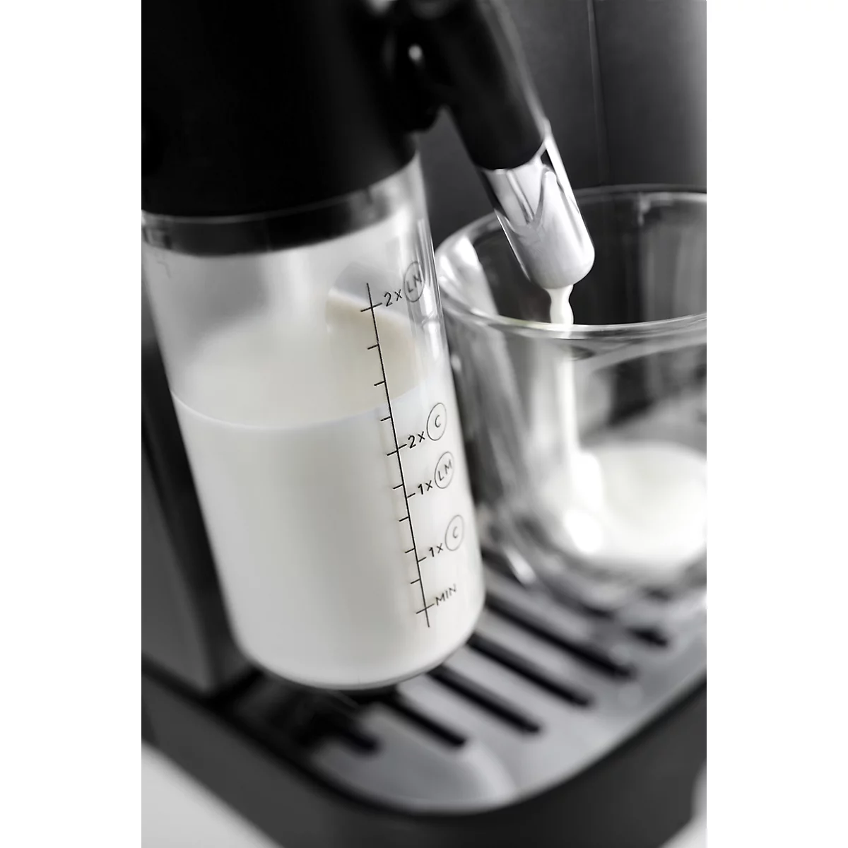 Milchbehälter einer Kaffeemaschine mit Skala füllt Milch in ein Glas.