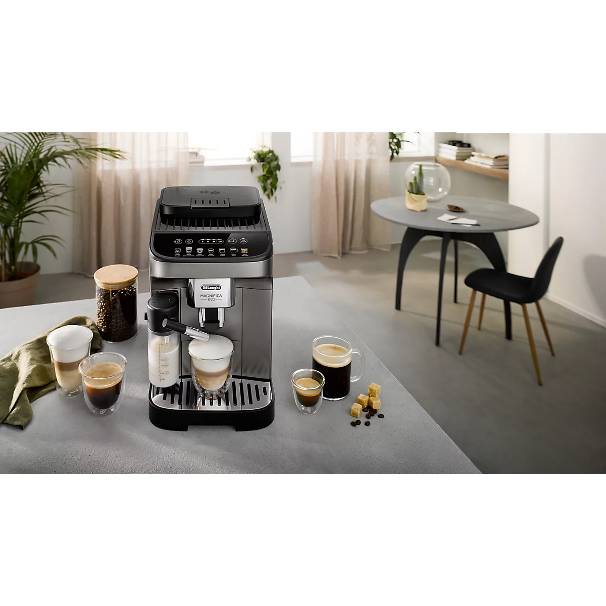 Kaffeevollautomat von De'Longhi auf einem Küchentisch, umgeben von Kaffeetassen und Zubehör.