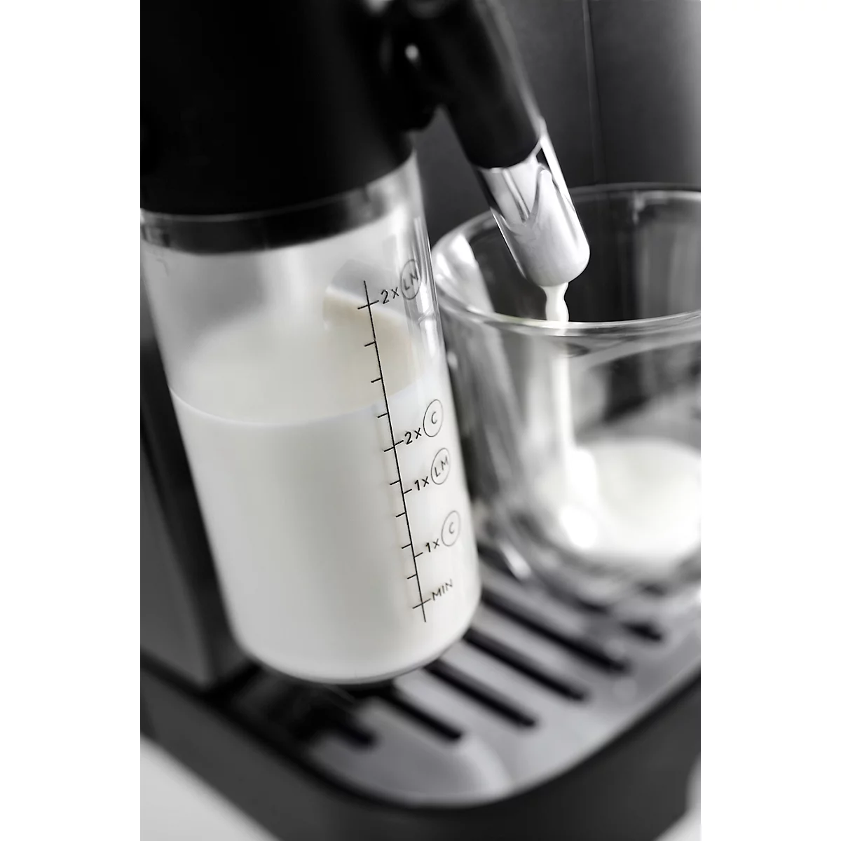 Milch wird in ein Glas gefüllt, Detailaufnahme von einer Kaffeemaschine.