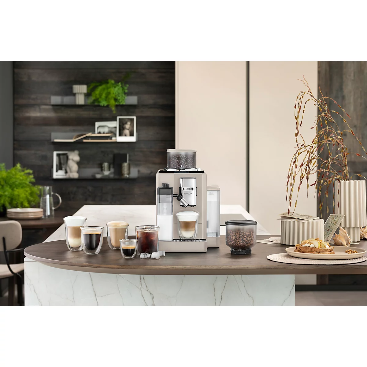 Kaffeemaschine mit Gläsern unterschiedlicher Kaffeesorten auf einer Theke. Im Hintergrund Dekoration und Pflanzen.