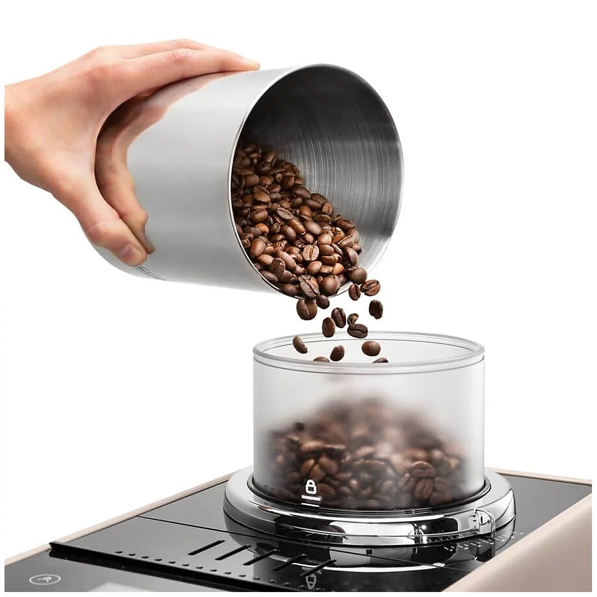Hand gießt Kaffeebohnen aus einem Metallbehälter in einen transparenten Behälter einer Kaffeemaschine.