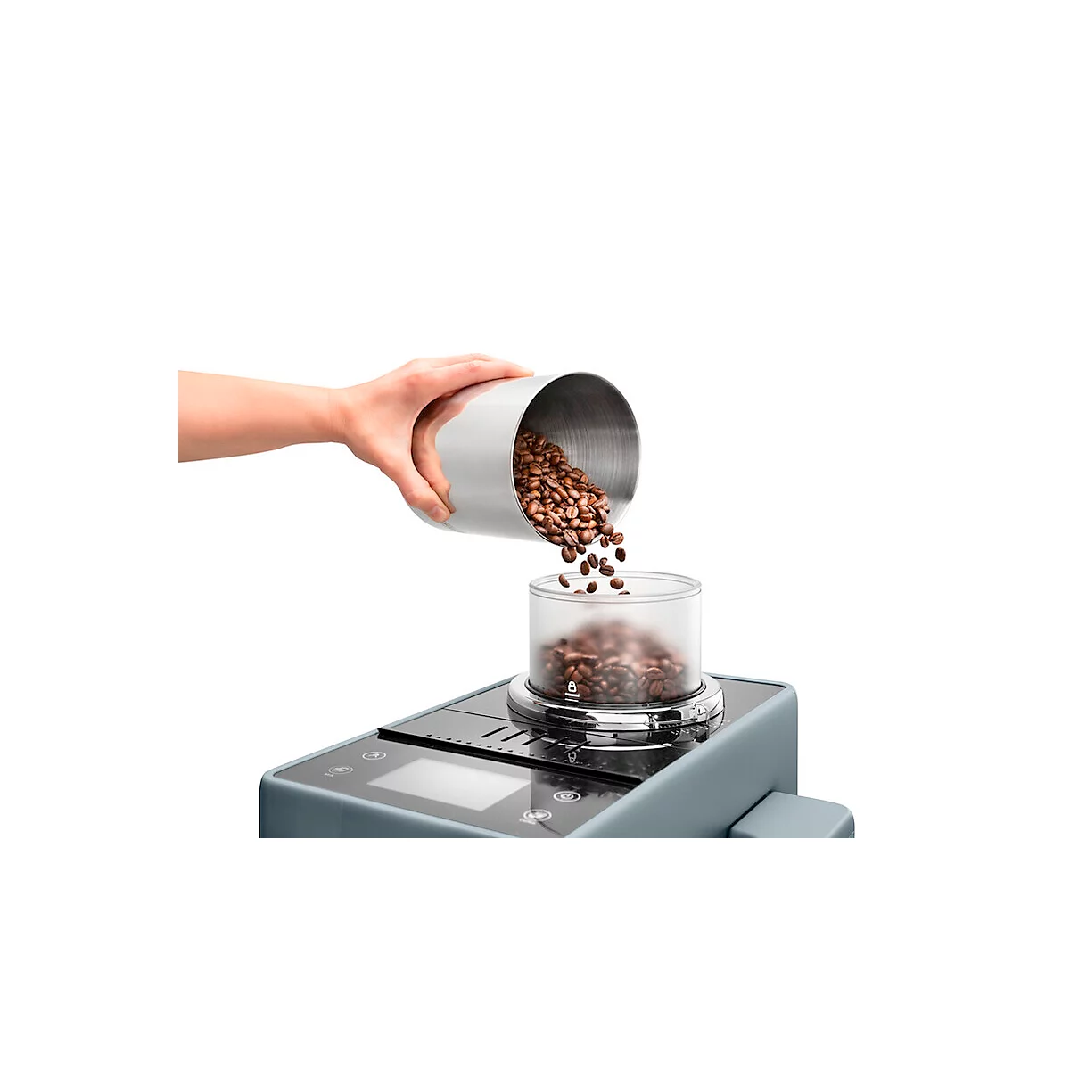 Hand schüttet Kaffeebohnen aus einem silbernen Behälter in eine transparente Kammer.