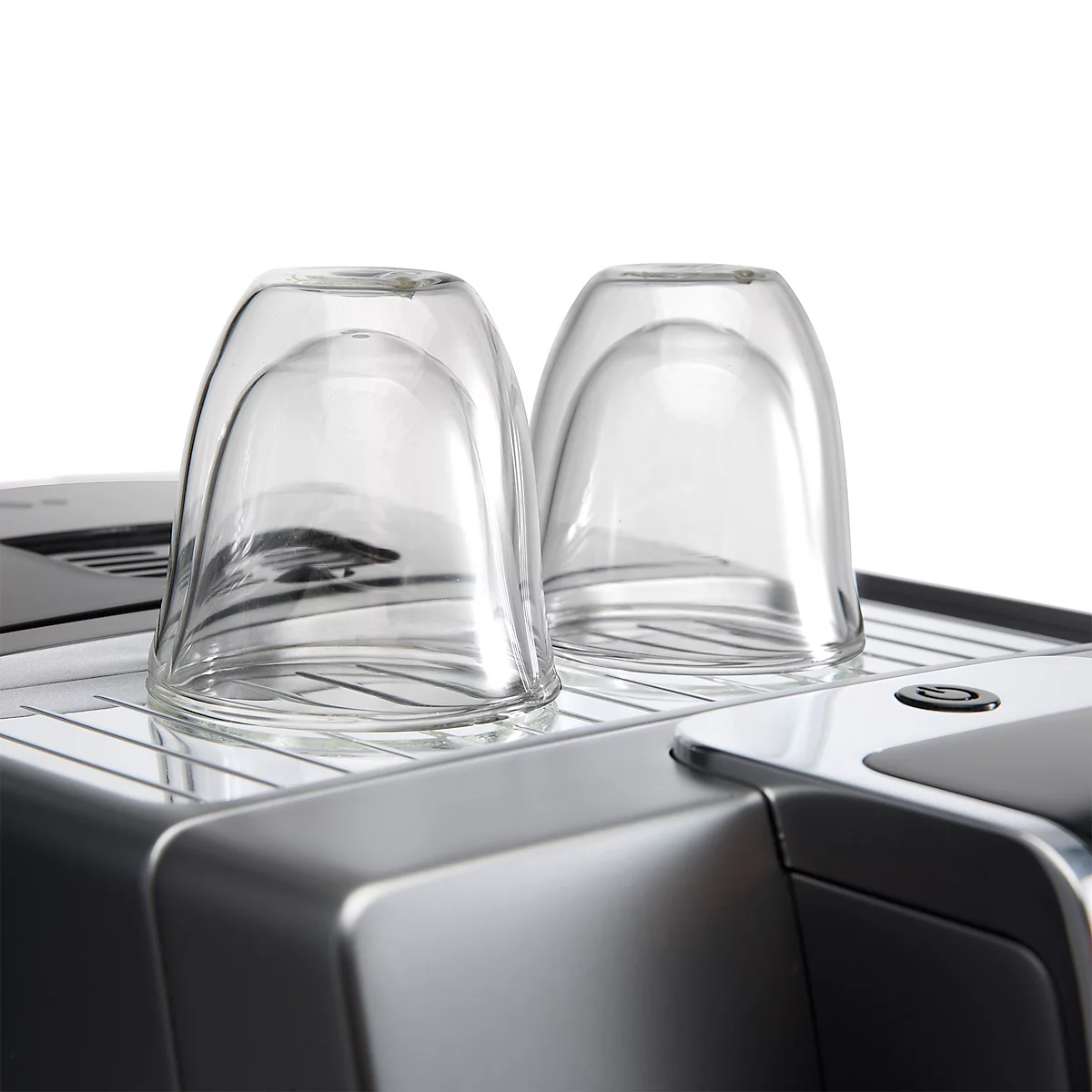 Twee omgekeerde glazen op een koffiemachine. Het zilverkleurige metaal contrasteert met de witte achtergrond.