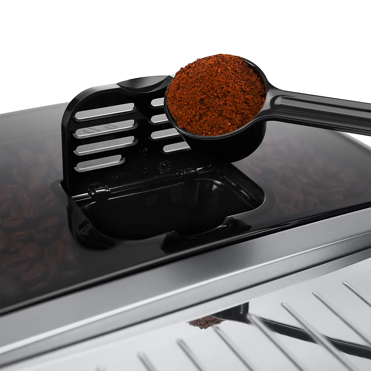 Close-up van een koffiemachine. Een lepel met koffiepoeder wordt in een bak gevuld.