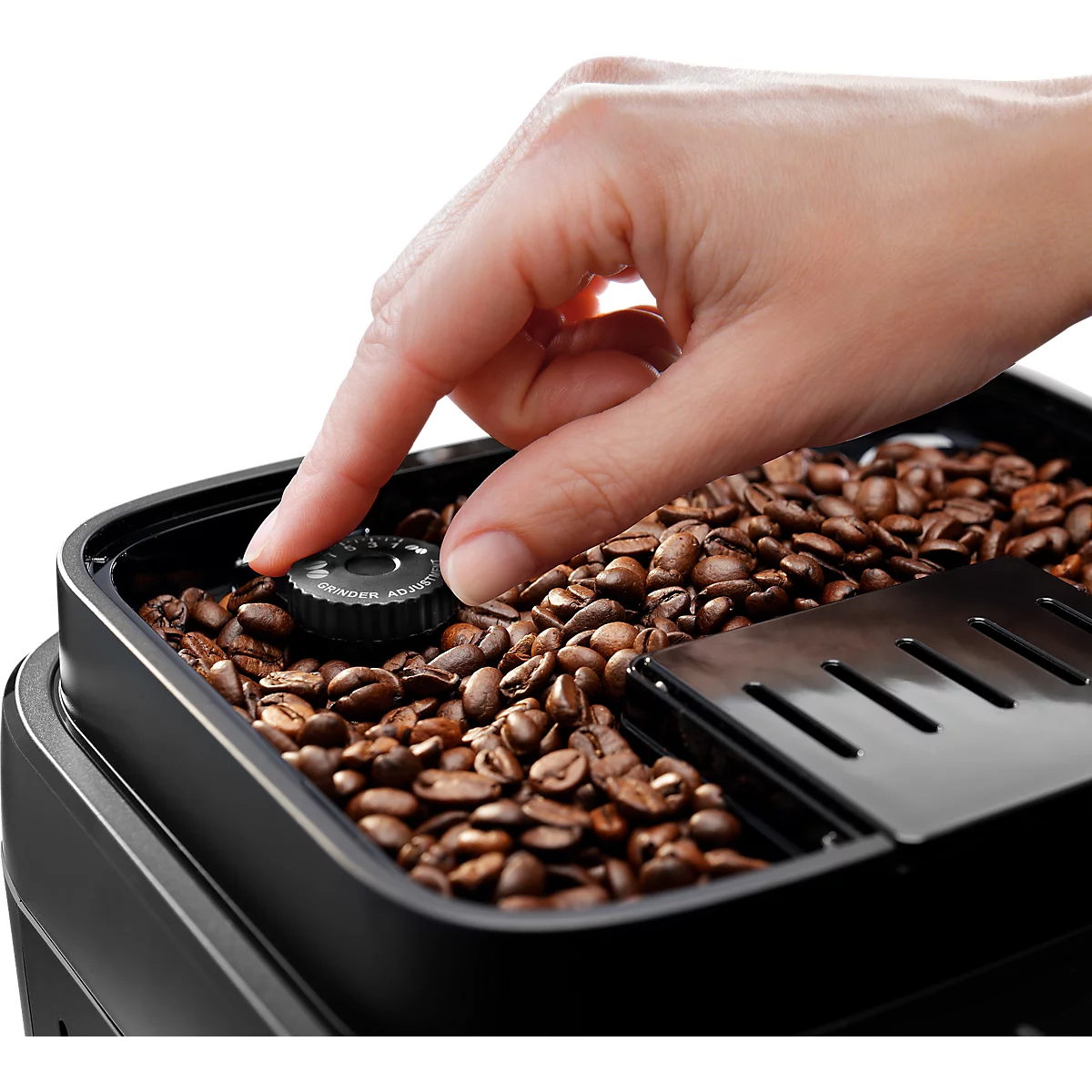 Hand stelt de maalgraad in in het bonenreservoir van een koffiemachine.