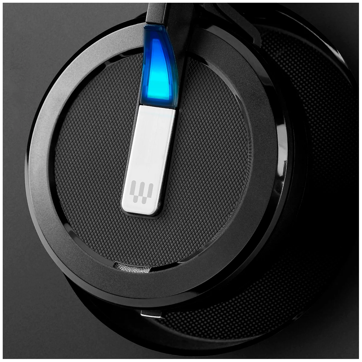 Close-up of black headphones with blue illuminated detail and logo.
