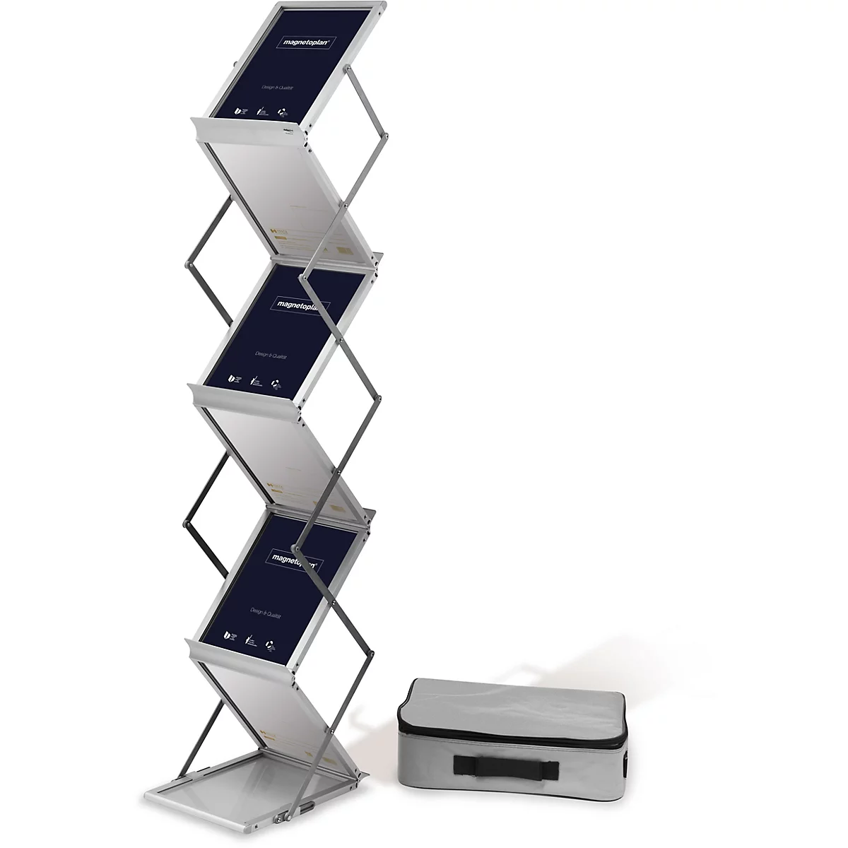 Un présentoir de brochures pliable argenté avec plusieurs compartiments. Sur les panneaux, on peut lire "magnetoplan Design & Qualität". Un sac de transport gris est à côté.