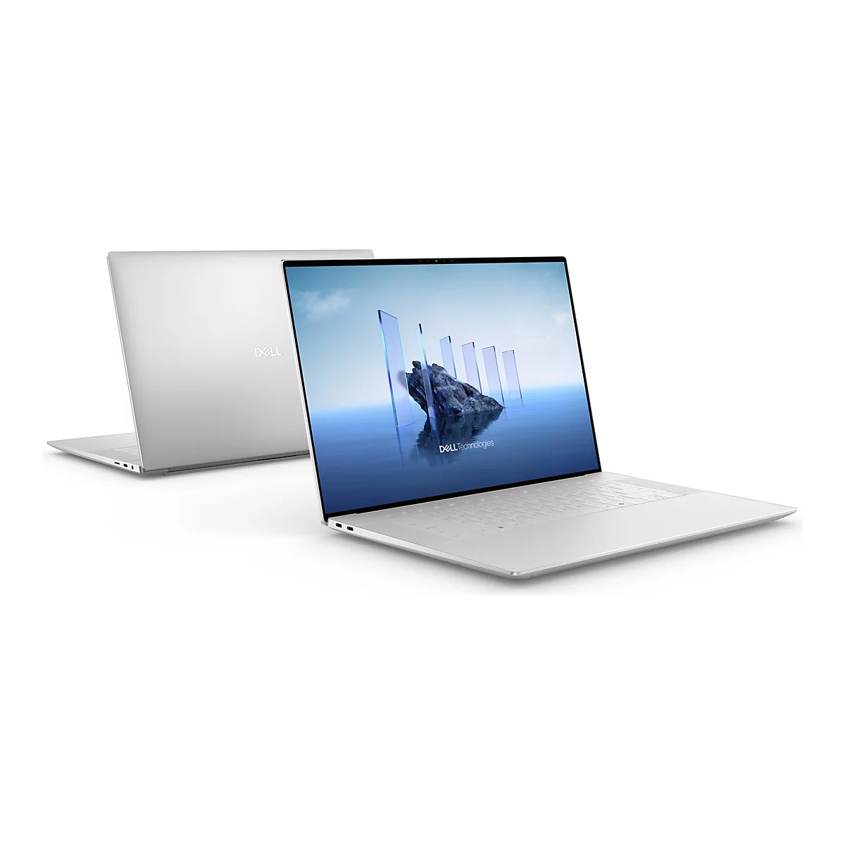 Ein silberner Laptop, der leicht geöffnet auf einer weißen Oberfläche steht. Ein weiterer Laptop, im geschlossenen Zustand, ist im Hintergrund zu sehen. Auf dem Bildschirm sind transparente Formen und der Schriftzug Dell Technologies abgebildet.