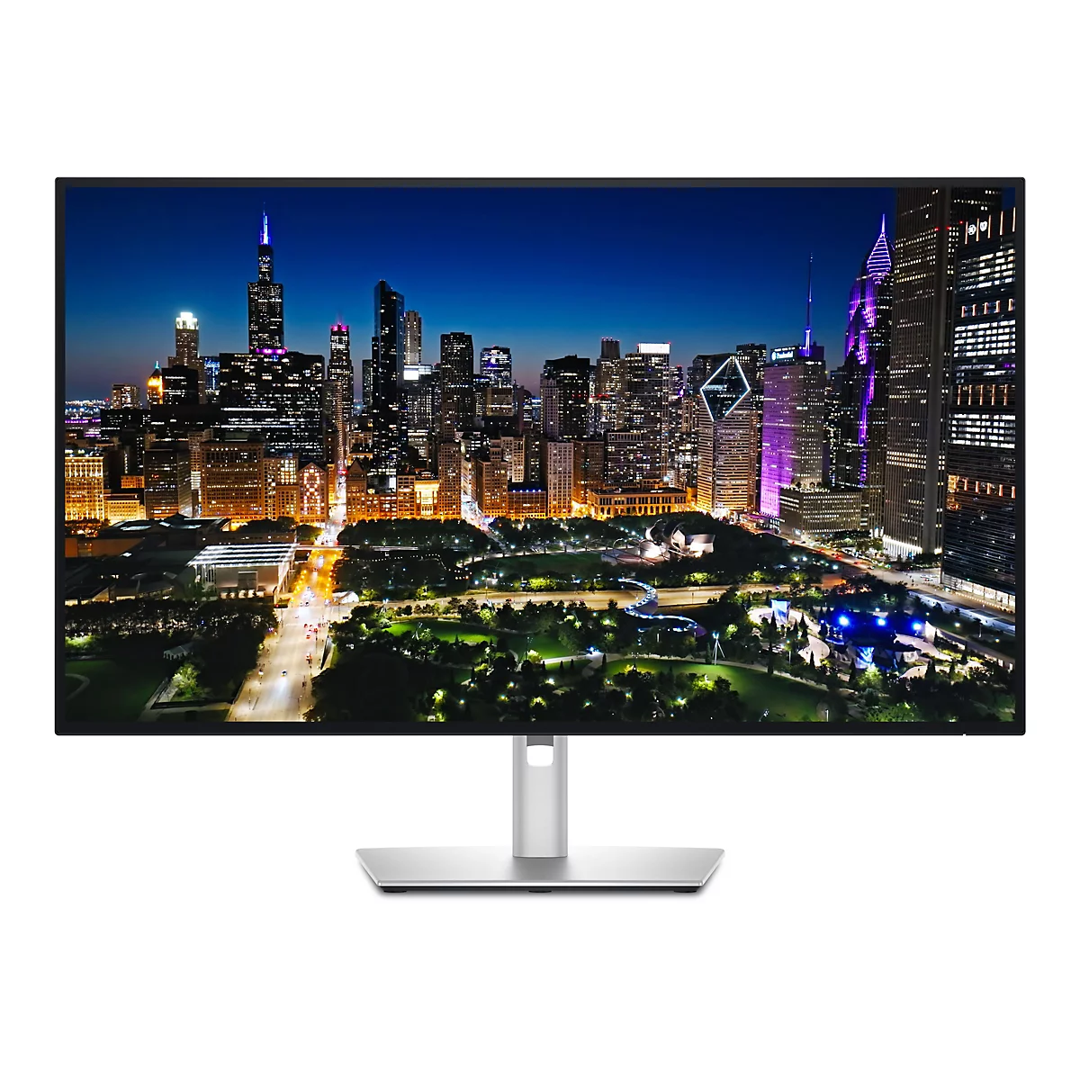 Ein Computermonitor mit einem nächtlichen Stadtpanorama im Display, mit hohen Gebäuden und bunten Lichtern.