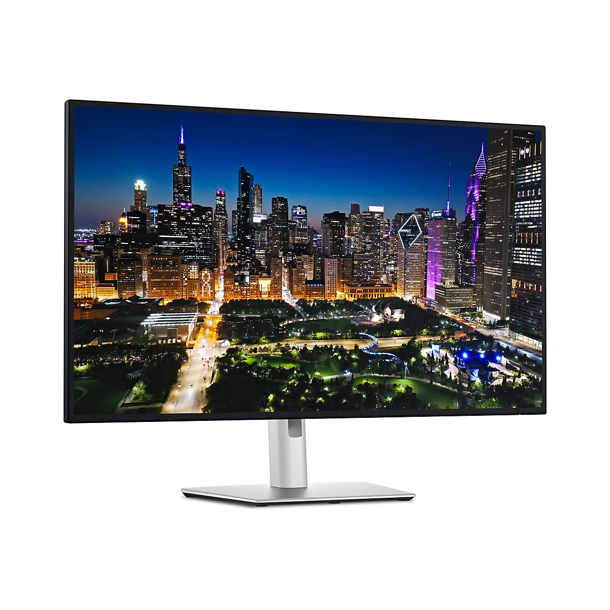 Monitor mit nächtlicher Stadtansicht. Hochhäuser mit Beleuchtung, blauer Himmel.