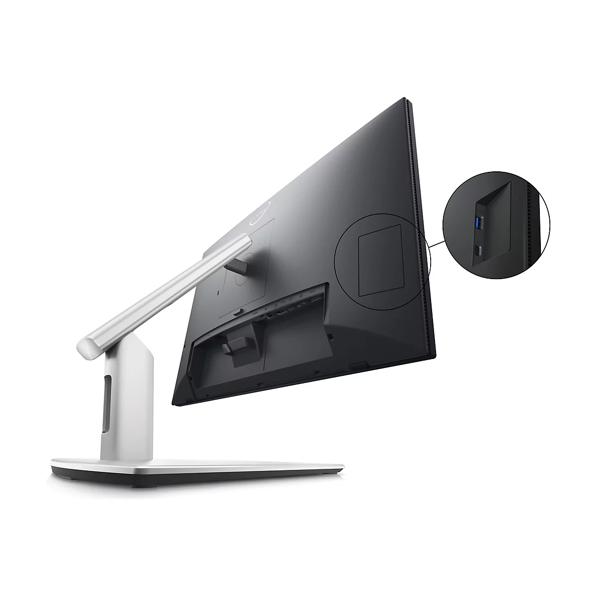 Der Monitor ist von hinten in einer leicht schrägen Perspektive zu sehen. Der Bildschirm ist schwarz, der Rahmen ist ebenfalls dunkel, aber die Halterung und der Standfuß sind silbern. In einer Vergrößerung sind USB-Anschlüsse zu erkennen.