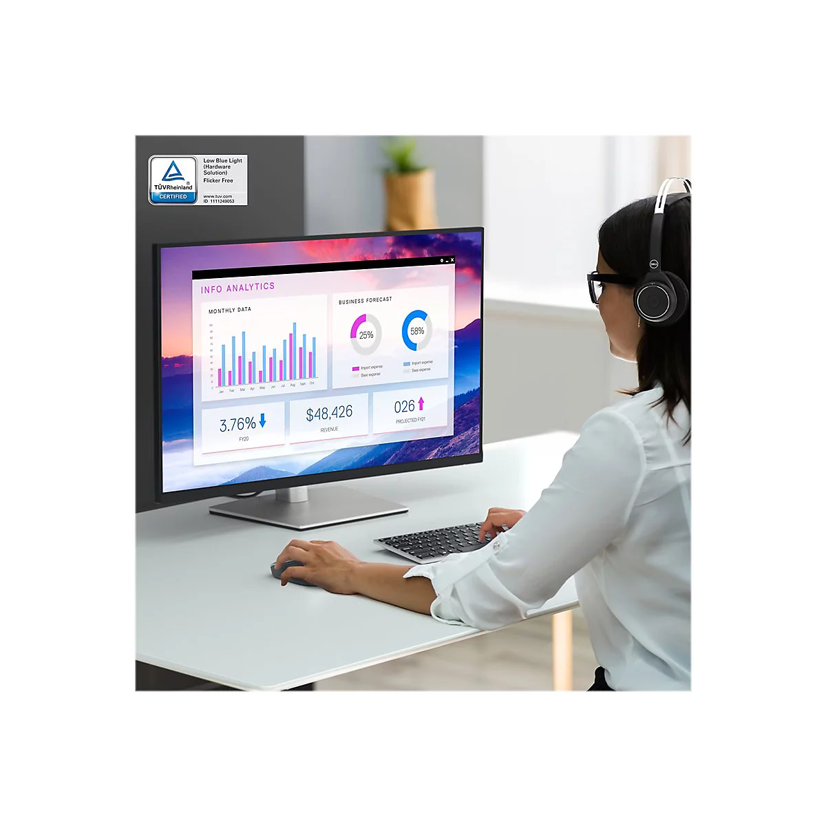 Person mit Brille und KopfhÃ¶rern sitzt vor einem Monitor mit Diagrammen. Tastatur auf dem Tisch.