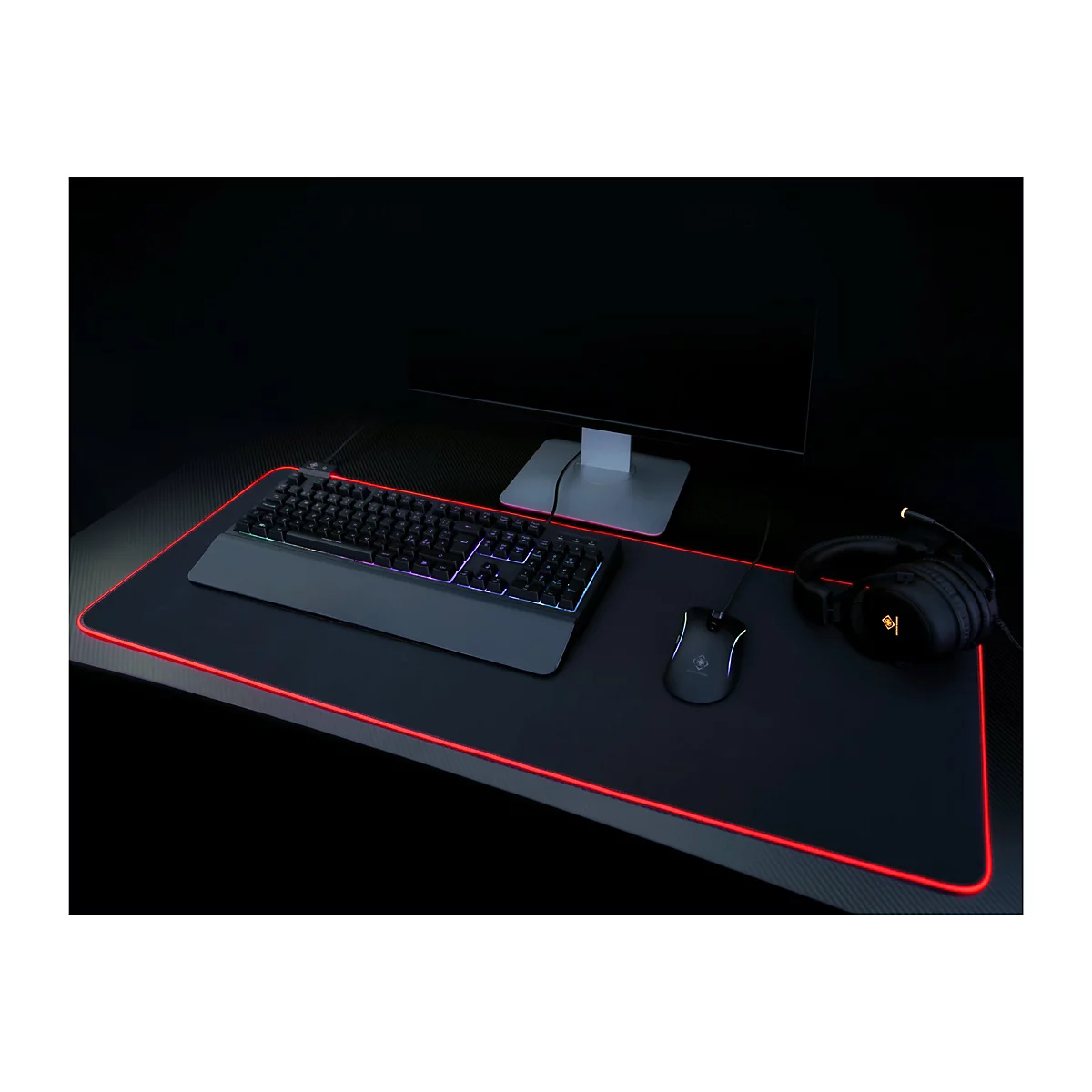 Ein schwarzer Gaming-Schreibtisch, der mit Tastatur, Maus, Kopfhörern und Monitor ausgestattet ist. Der Schreibtisch hat eine rote LED-Beleuchtung.