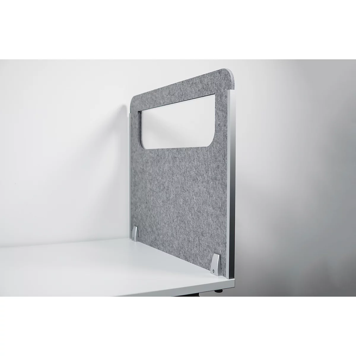 Gray desk partition with cutout, against a white wall and on a white desk.