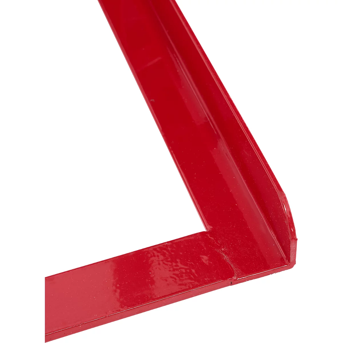 Gros plan d'une pièce métallique rouge angulaire, ressemblant à un coin. La peinture brillante réfléchit la lumière.