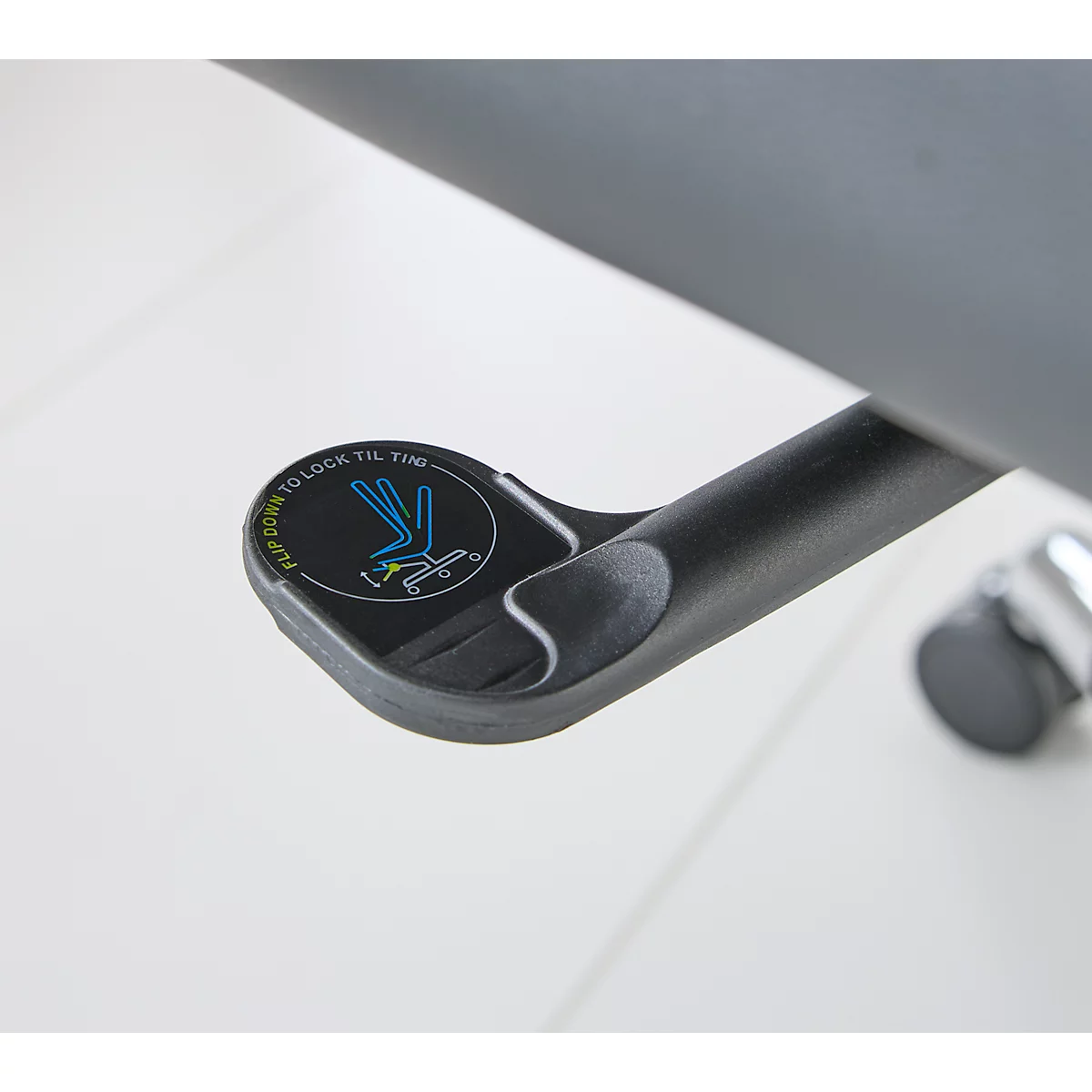 Detail van een zwart stoelmechanisme met de tekst voor kantelvergrendeling.