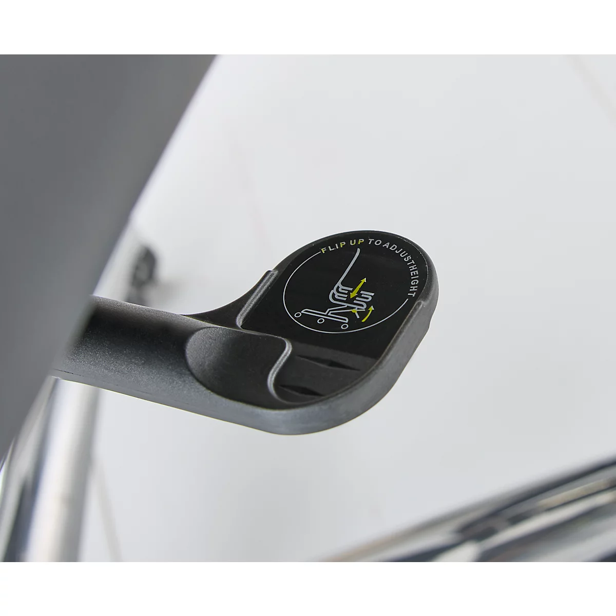 Close-up van een zwarte hendel met een ronde knop. Op de knop staat: "Flip up to adjust".