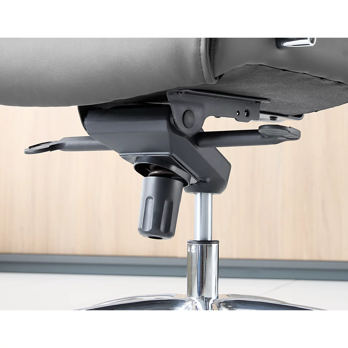 Close-up van het onderste deel van een bureaustoel, met details van de hoogteverstelling.