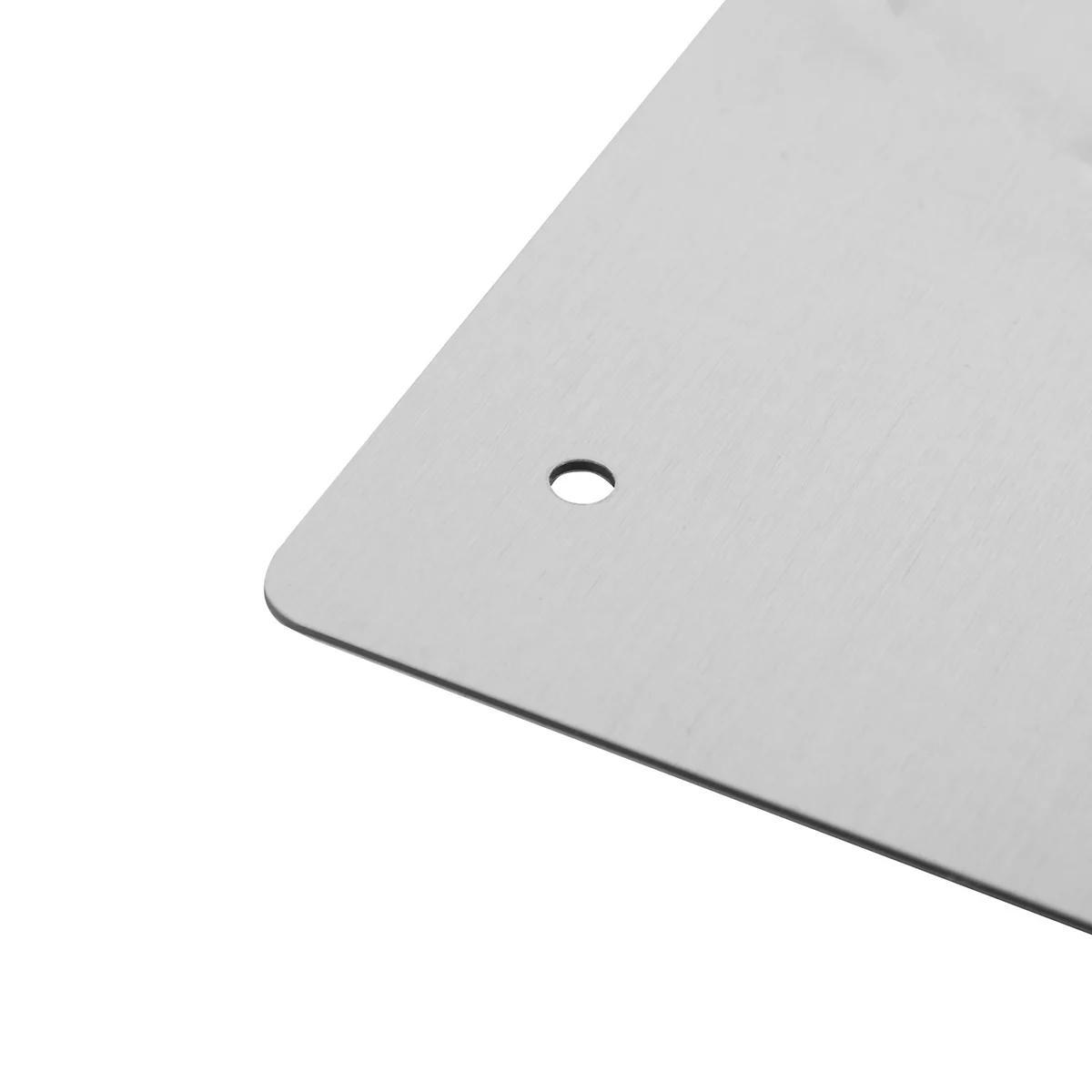Nahaufnahme einer gebürsteten Aluminiumplatte mit einer Ecke und einem kreisrunden Bohrloch.