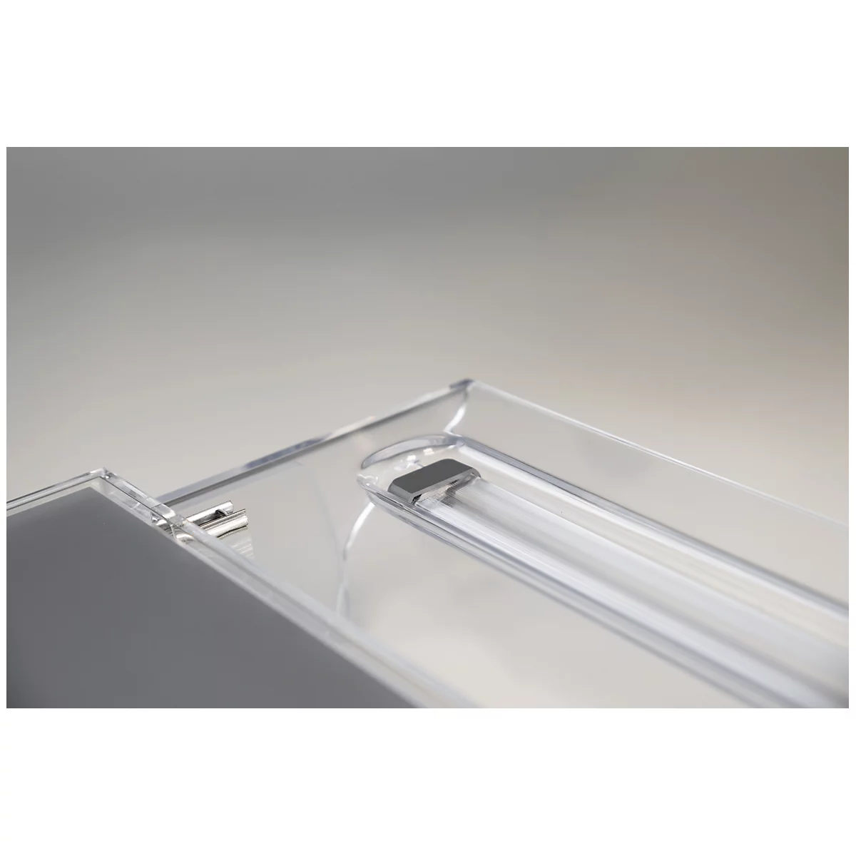 Close-up of a transparent lamp with built-in fluorescent tube. The lamp has a rectangular, clear plastic frame.