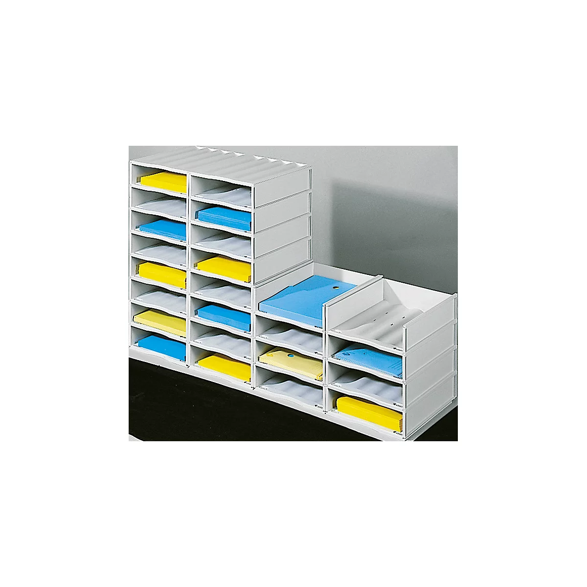 White file organizer with compartments filled with yellow and blue papers.
