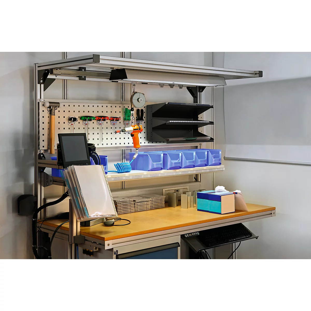 Workbench with pegboard, tools, drawers, and a lamp.