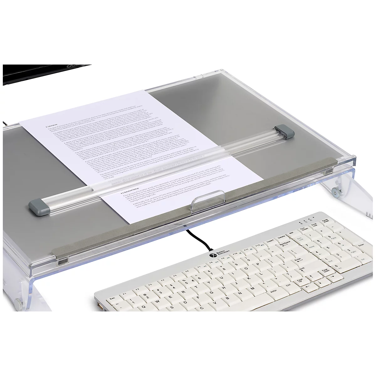 Transparante documenthouder met papier, toetsenbord en monitor op de achtergrond.