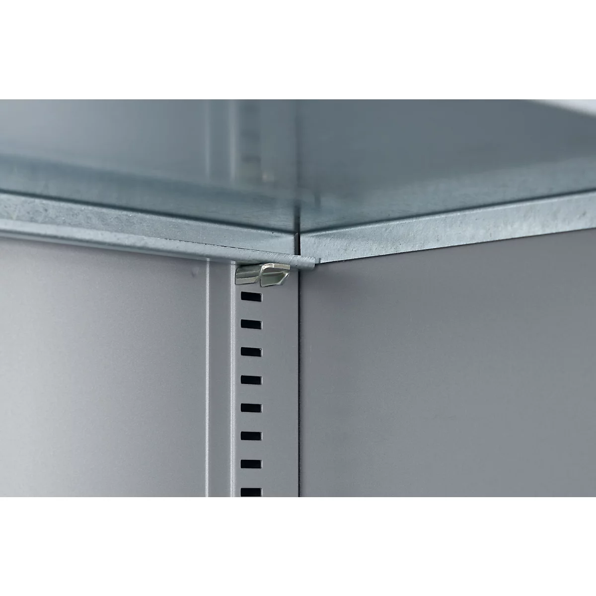 Detailweergave van een hoekverbinding van een metalen plank. Grijze metalen platen, in elkaar grijpend met kleine beugels.