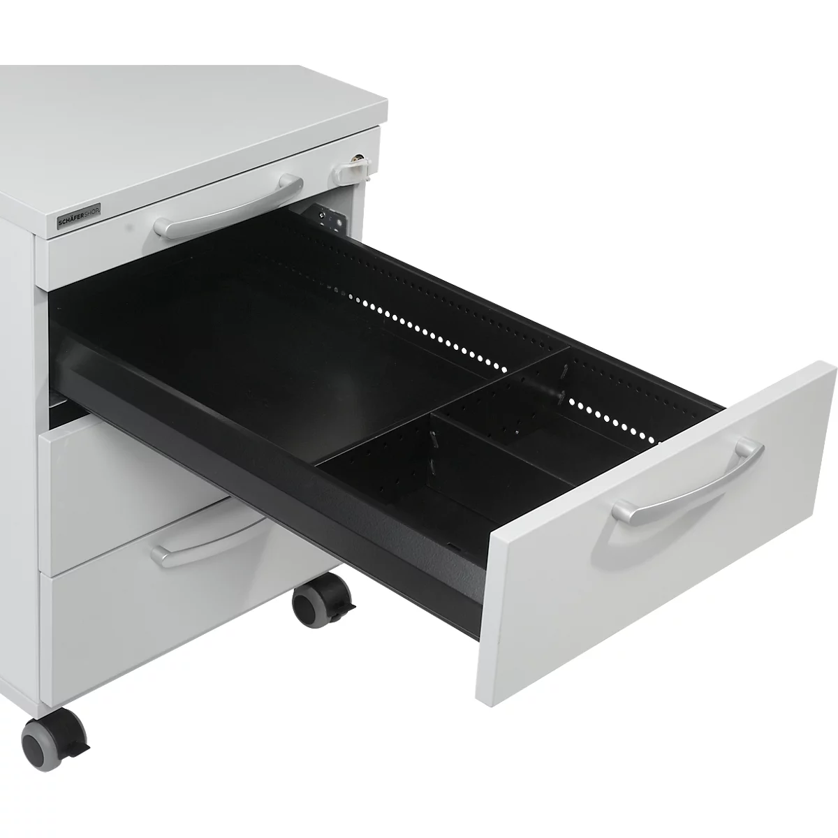 A white office cabinet, the bottom drawer is pulled out, black inside with compartments.