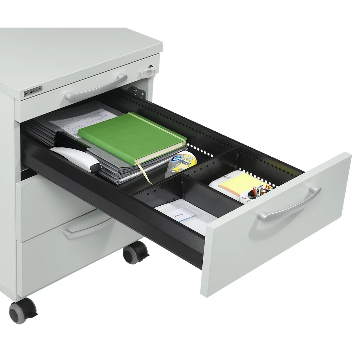 Opened gray drawer filled with office supplies like notepad, mouse, paper, sticky notes, and tape.