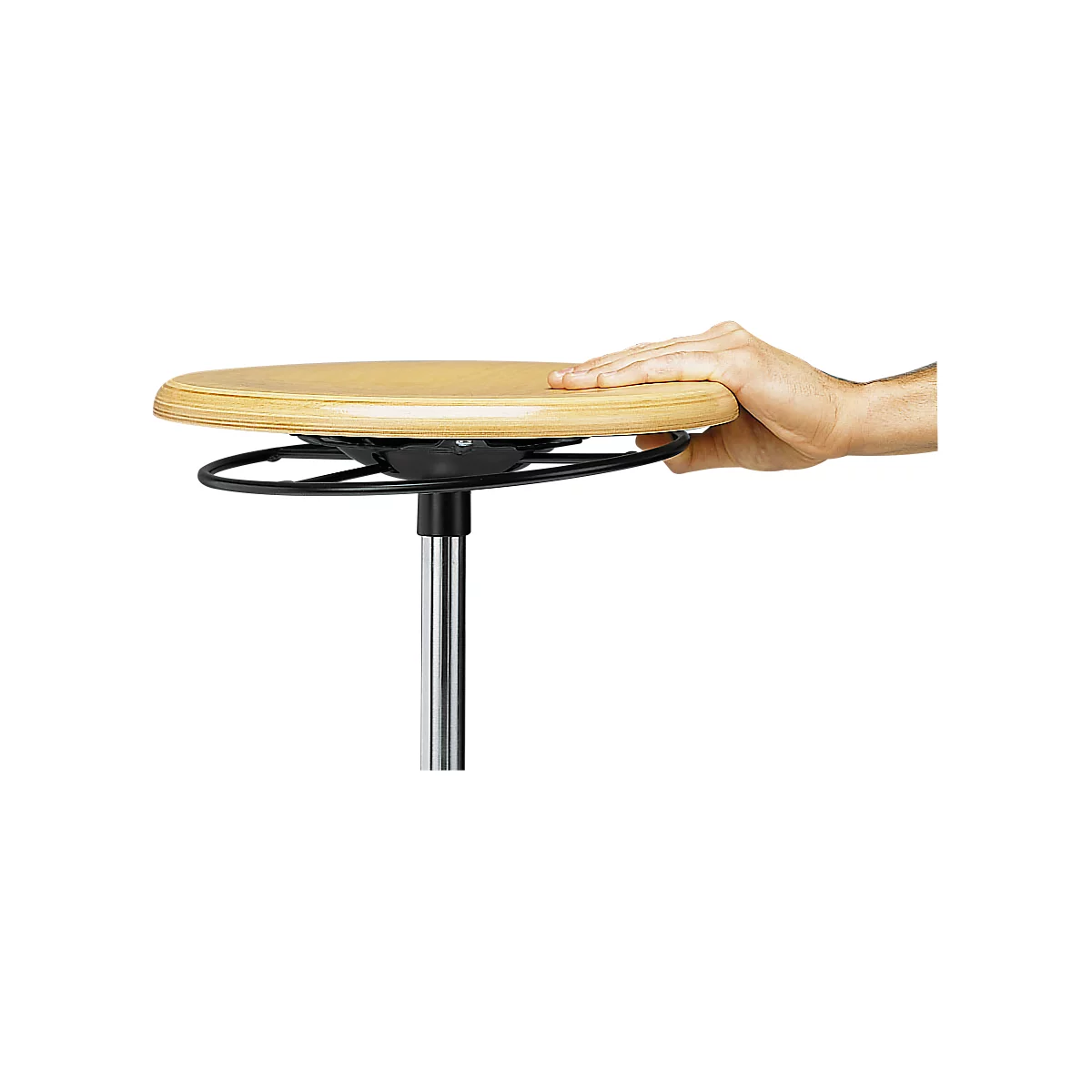Der runde, helle Holz-Sitz eines Stehhockers, gehalten von einer Hand, die auf dem Sitz liegt.