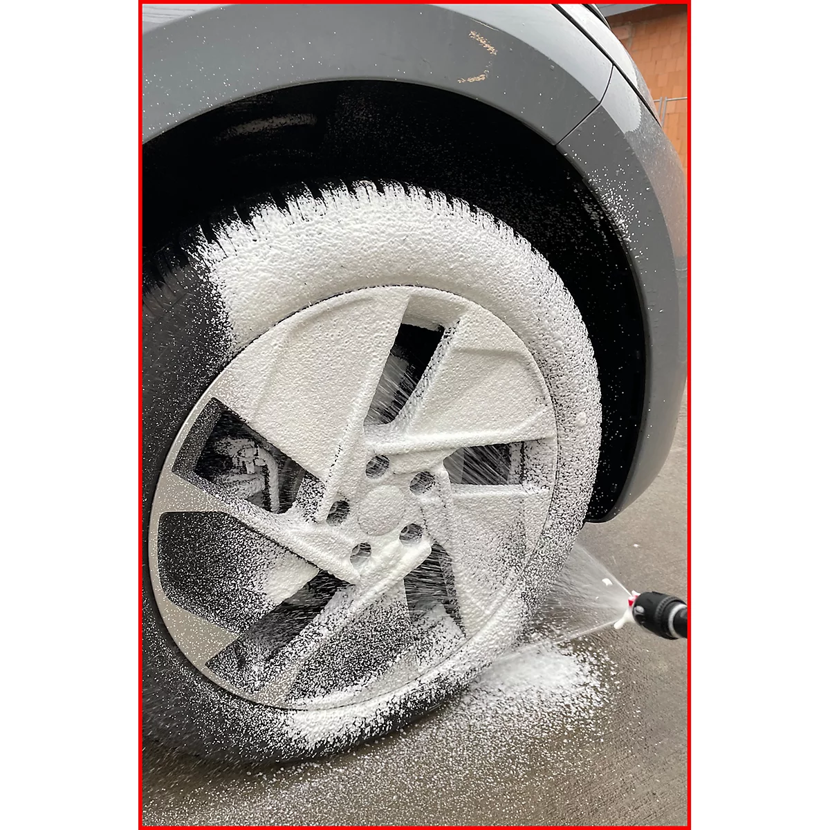 Autoreifen mit Felge wird mit Schaum gewaschen.