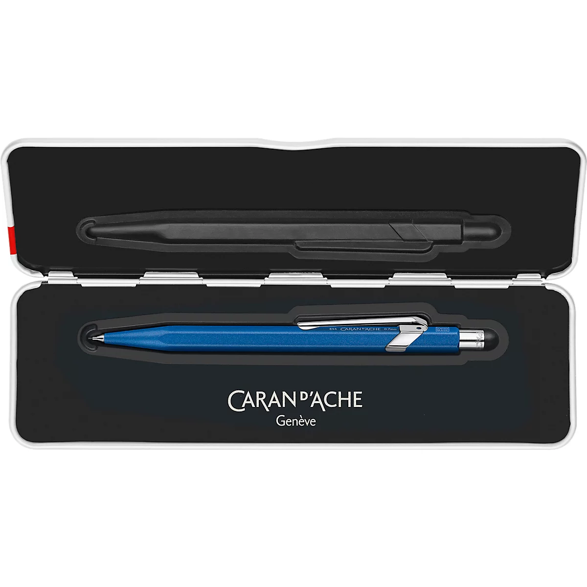Geöffnete weisse Box mit zwei Stiften: einem schwarzen und einem blauen. Aufschrift 'CARAN D'ACHE Genève'.
