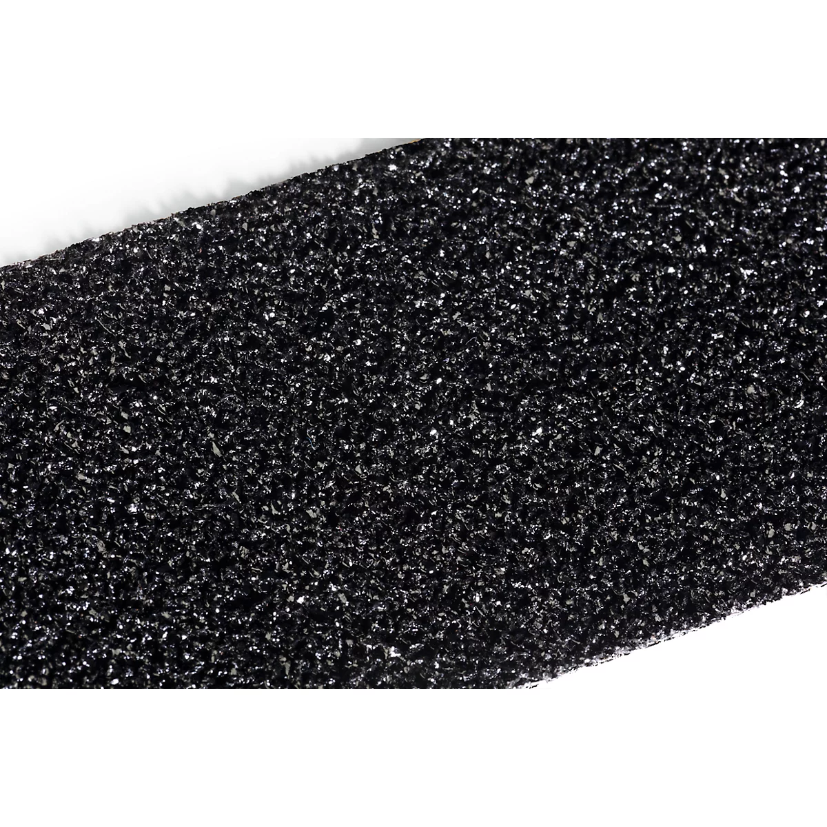 Close-up detail of a black, textured material with white, shiny particles.