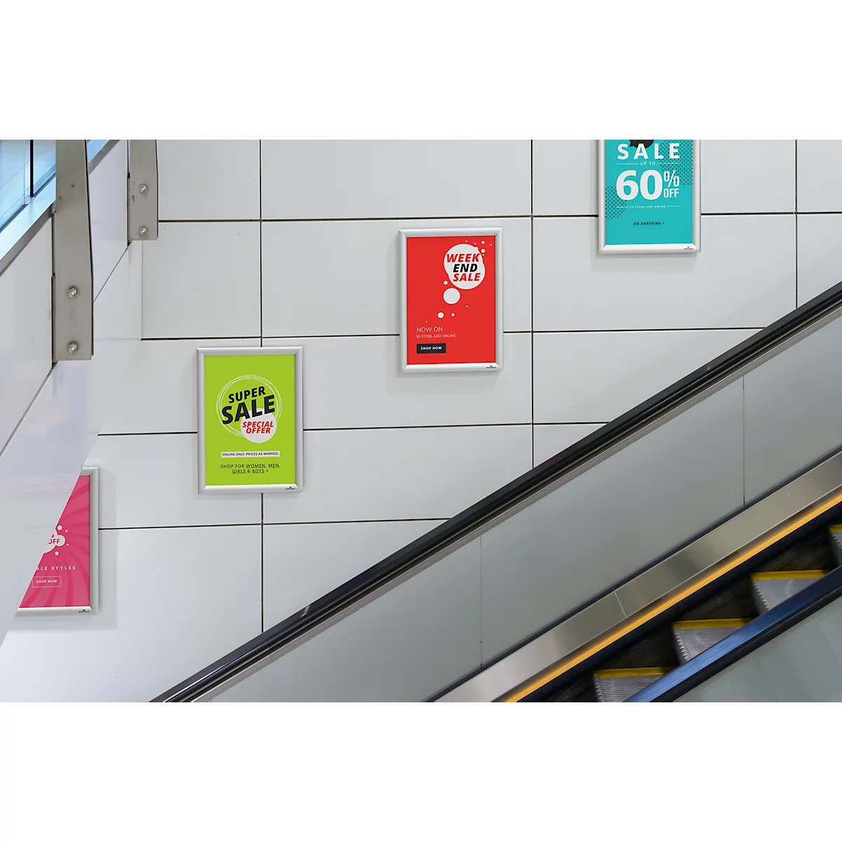 Werbung mit Schildern, darunter 'Super Sale' und 'Weekend Sale' an einer Wand neben einer Rolltreppe.