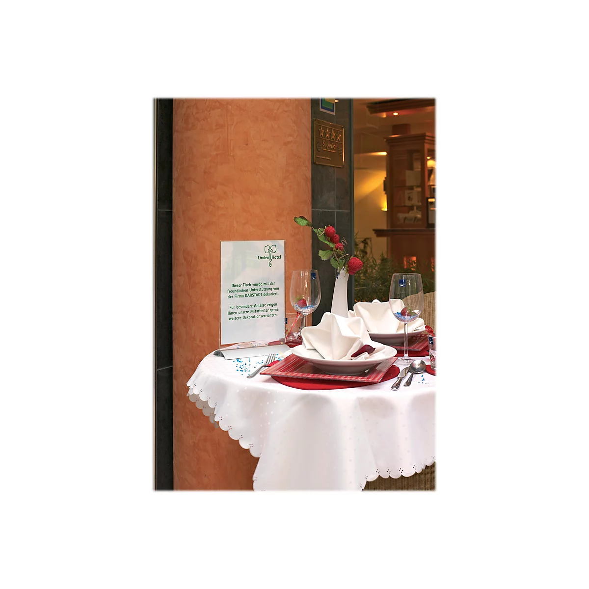 Festlich gedeckter Tisch im Linden Hotel mit Infoständer und Karstadt-Dekorationshinweis.