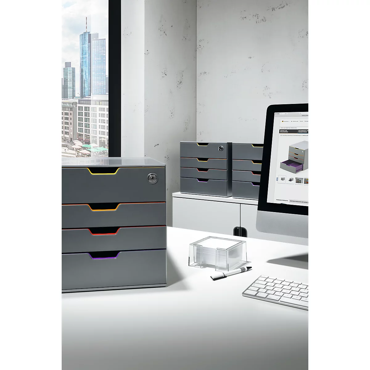 Gray drawer systems on desk. Skyline and computer in background.