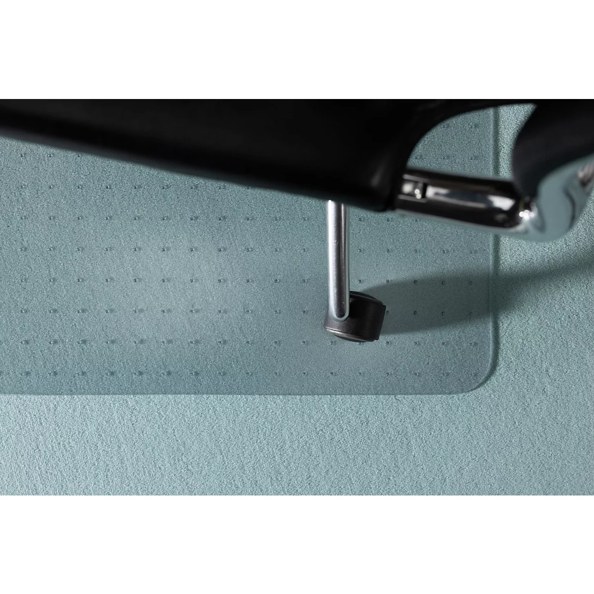 Primer plano del borde de la pata de una silla negra sobre una esterilla azul.