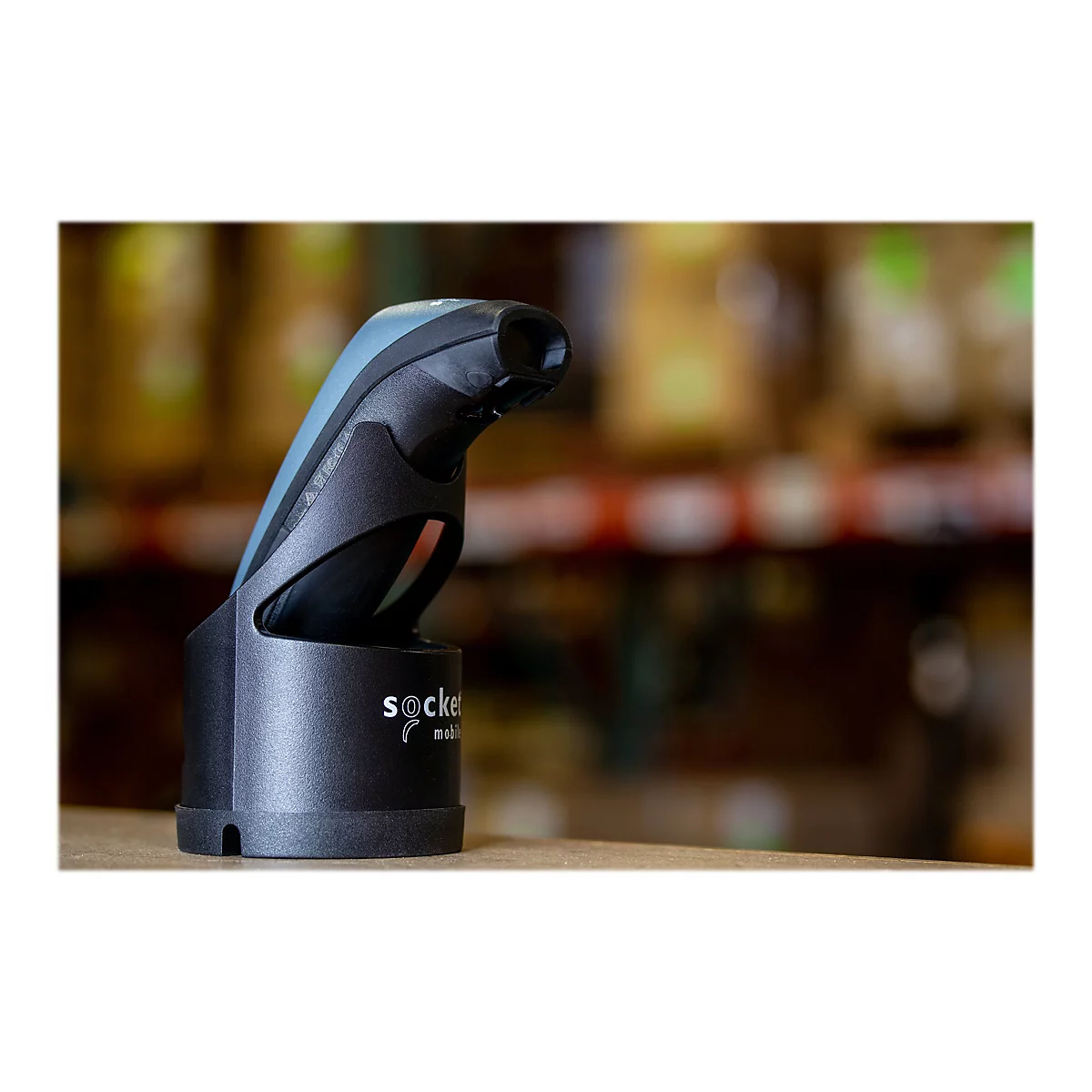 Ein schwarzer Barcodescanner steht in seiner Ladestation. Auf der Basis ist das Wort socket mobile geschrieben.