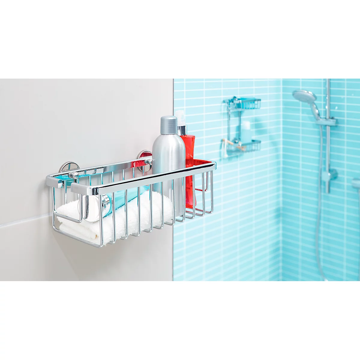 Verchromte Duschablage, gefüllt mit Handtuch und Pflegeprodukten. Blau gekachelte Wand, Dusche im Hintergrund.