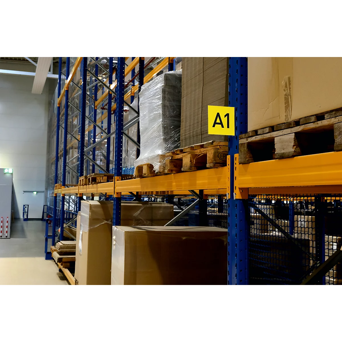 Magazijnstelling met pallets, dozen en een bordje met de tekst A1.